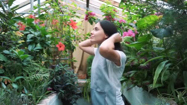 Jeune entrepreneur fleuriste apprécie la floraison des fleurs dans ma serre . — Video