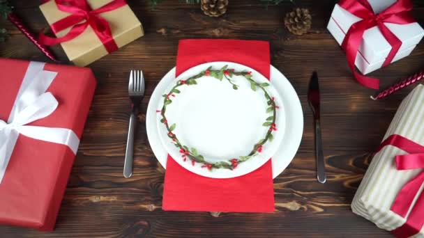 En la mesa de Navidad plato vacío y regalos — Vídeos de Stock