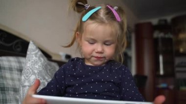 Halı döşemesinde dijital tablet teknolojisi kullanan meraklı anaokulu öğrencisi kız. Evde internette sörf yapan küçük bir çocuk. Çocuklar teknoloji bağımlılığı kavramı.