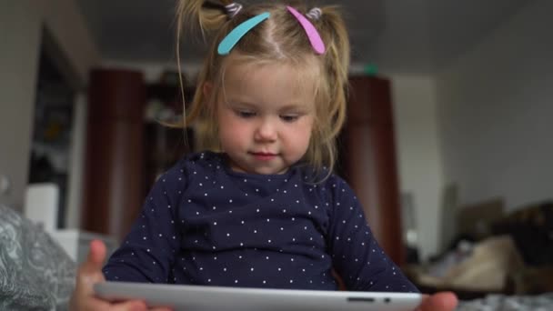 Halı döşemesinde dijital tablet teknolojisi kullanan meraklı anaokulu öğrencisi kız. Evde internette sörf yapan küçük bir çocuk. Çocuklar teknoloji bağımlılığı kavramı. — Stok video