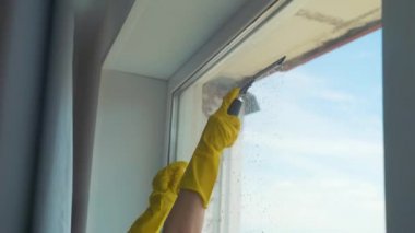 Kız profesyonel olarak dairedeki pencereleri yıkıyor, temizlik yapıyor.