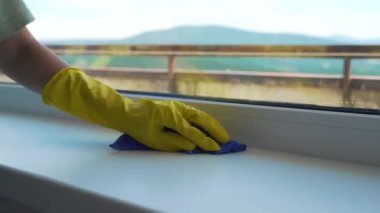 Kız profesyonel olarak dairedeki pencereleri yıkıyor, temizlik yapıyor.