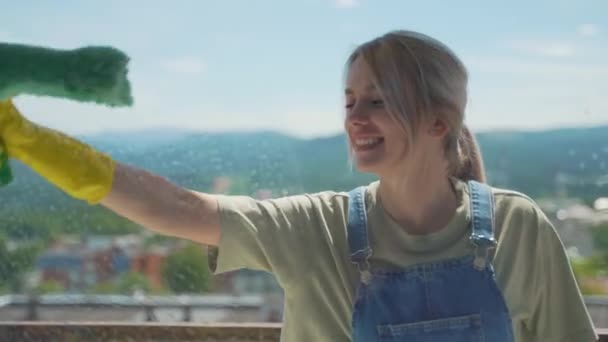 Het meisje is professioneel wassen van de ramen in het appartement, schoonmaken — Stockvideo