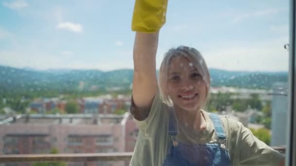 Gyönyörű lány a takarító cég mossa ablakok — Stock videók