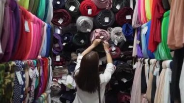 Kız kumaşı kumaş dükkanından seçiyor.