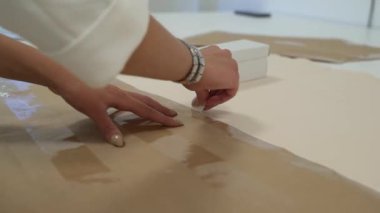 Kız kumaşın çevresindeki deseni özetliyor