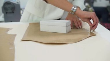 Yakın plan. Stüdyodaki kumaşın dış hatlarına modelin ana hatlarını çizen kız.
