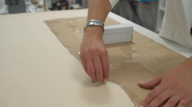 Kız kumaşın çevresindeki deseni özetliyor