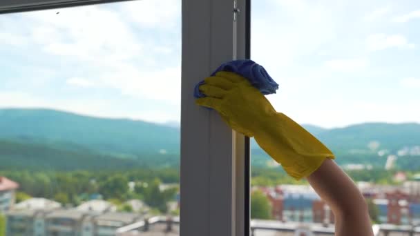 A sárga kesztyűs lány egy koszos ablakot mos zöld szivaccsal. — Stock videók