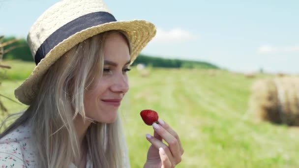 Portret młodej dziewczyny jedzącej truskawki. — Wideo stockowe