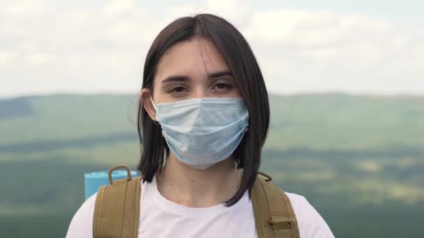 Porträt eines ernsten Mädchens in Schutzmaske, das auf einem Berg steht. — Stockvideo