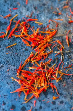 Mavi bir taş zemin üzerine safran baharat kurutulmuş. 