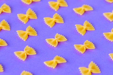 Farfalle makarna mor bir arka plan üzerinde köşegenleri. 