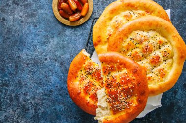 Türk ramazan pidesi - geleneksel Türk Ramazan flatbreads genellikle Ramazan ayı boyunca pişmiş. Mavi taş arka plan. Üstten Görünüm.