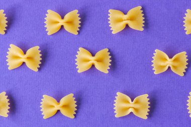 Farfalle makarna mor bir arka plan üzerinde köşegenleri. 