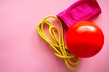 Kırmızı jimnastik topu, dizlikler ve bir pembe ip atlama. Spor, hobi ve yaşam tarzı kavramı. En iyi görünüm ve kopya alanı.
