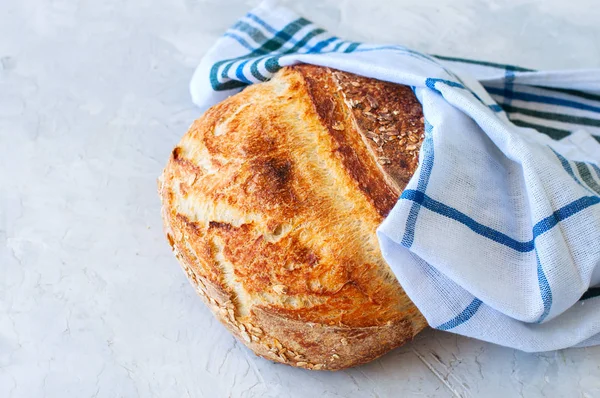 Homemade sourdough bread on a white stone background.