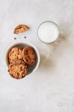 Bir kase ve galss taze süt beyaz taş zemin üzerine ev yapımı çikolatalı kurabiye.