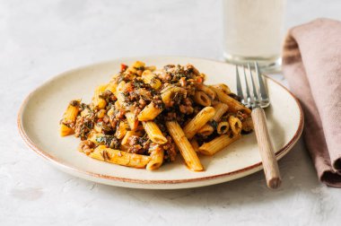 Domates sosu zemin sığır eti makarna beyaz taş zemin üzerine. Tonda.