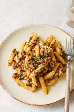 Domates sosu zemin sığır eti makarna beyaz taş zemin üzerine. Tonda.