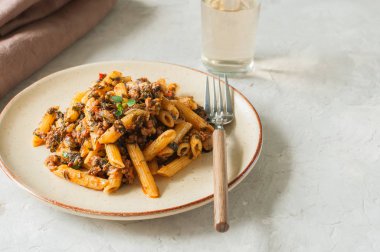 Domates sosu zemin sığır eti makarna beyaz taş zemin üzerine. Tonda.