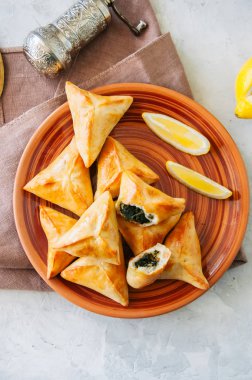 Arap ve Ortadoğu gıda kavramı. Fatayer sabanekh - geleneksel Arapça ıspanak üçgen el turta beyaz taş zemin üzerine. 