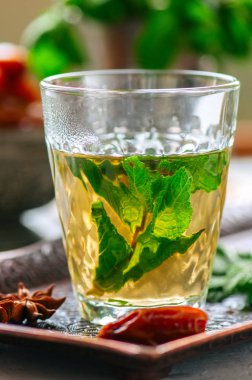 Vintage bir tepsi üzerinde tarihleri ile geleneksel Fas nane çayı. Beyaz taş zemin. Yakın çekim.