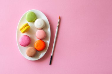 Renkli macarons çerezleri bir beyaz tabak, üstten görünüm, gıda arka plan kavramı.