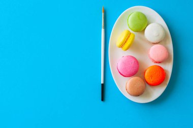 Renkli macarons çerezleri bir beyaz tabak, üstten görünüm, gıda arka plan kavramı.