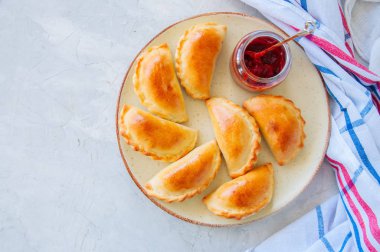Ev yapımı patates empanadas ketçap ile tabağa doldurulmuş. Beyaz taş zemin.