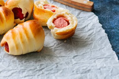 Domuz sosisli bir fırın kağıt üzerinde. Yakın çekim. Fast food, bira atıştırma veya öğle yemeği kutusu gıda kavramı.