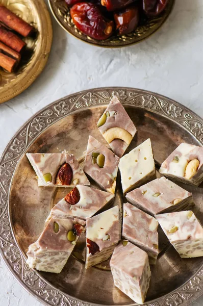 Vintage tabakta geleneksel Doğu tatlı - helva ile fındık ve tohumlar. 