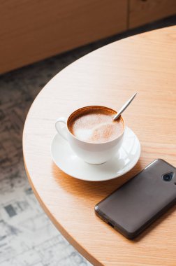 Fincan kahve ve bir çalışma tablosu akıllı telefon. Uzay kopyalayın. Üstten görünüm.