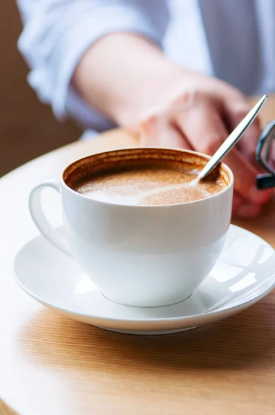 Close Xícara Café Uma Mesa Trabalho Mulher Segurando Seus Óculos — Fotografia de Stock