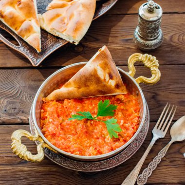 Turkish traditional breakfast - Menemen with scrambled egss, tomatoes on a wooden background. clipart