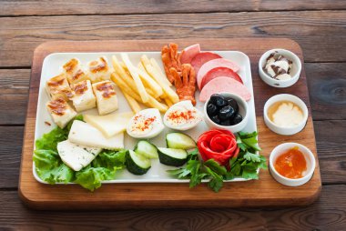 Akdeniz aperatifler ayarla veya ahşap bir gemide Odaya Servis Kahvaltı. Zeytin, beyaz peynir, sosis, domates, reçel, tereyağı, yumurta, patates, salatalık. 