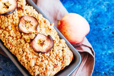 Ev yapımı elma pasta bir tel raf beyaz taş zemin üzerine alınarak parçalamak. Yakın çekim.