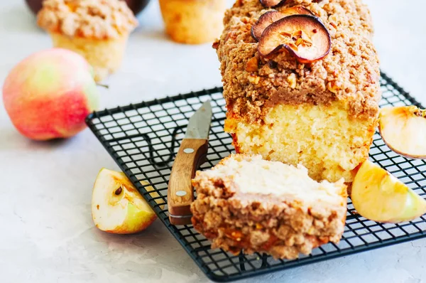 Ev yapımı elma pasta bir tel raf beyaz taş zemin üzerine alınarak parçalamak. Yakın çekim.