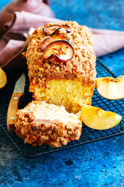 Ev yapımı elma pasta bir tel raf beyaz taş zemin üzerine alınarak parçalamak. Yakın çekim.