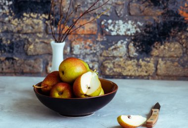 Bir tabak içinde tüm ve dilimlenmiş armutlar Grup