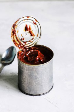 Dulce de leche karamel bir kutu içinde yakın teneke. Beyaz taş zemin
