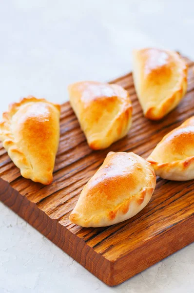 Empanadas de patata rellenas caseras en un tablero de madera . — Foto de Stock