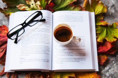 Göz gözlüğü, kitap ve bir akçaağaç yaprakları espresso fincan