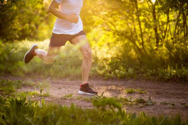 Doğada koşan atletik genç adam. Sağlıklı yaşam tarzı