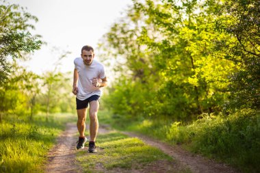  Doğada koşan atletik genç adam. Sağlıklı yaşam tarzı