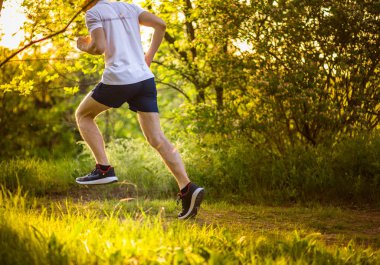 Doğada koşan atletik genç adam. Sağlıklı yaşam tarzı