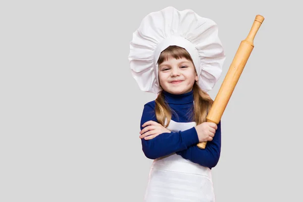 シェフの制服を着た幸せな少女は 明るい背景に分離された麺棒を保持しています 子供のシェフ 調理プロセスの概念 — ストック写真