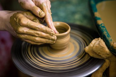 Clay, seçici odak vazo yapma önlük potter yakın çekim elleri. Birlikte zorlaştırıyor. Çanak çömlek çarkı seramik potu kazanmak için öğretim Potter üstten görünüm