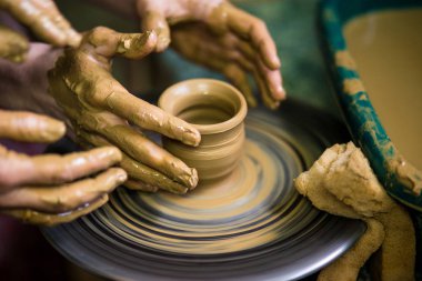 Clay, seçici odak vazo yapma önlük potter yakın çekim elleri. Birlikte zorlaştırıyor. Çanak çömlek çarkı seramik potu kazanmak için öğretim Potter üstten görünüm