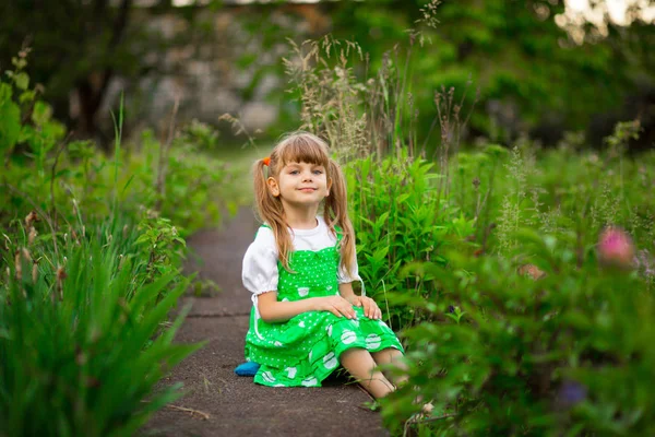 Μικρό Κορίτσι Που Κάθεται Στο Πράσινο Γρασίδι Είδη Κήπου Στην — Φωτογραφία Αρχείου